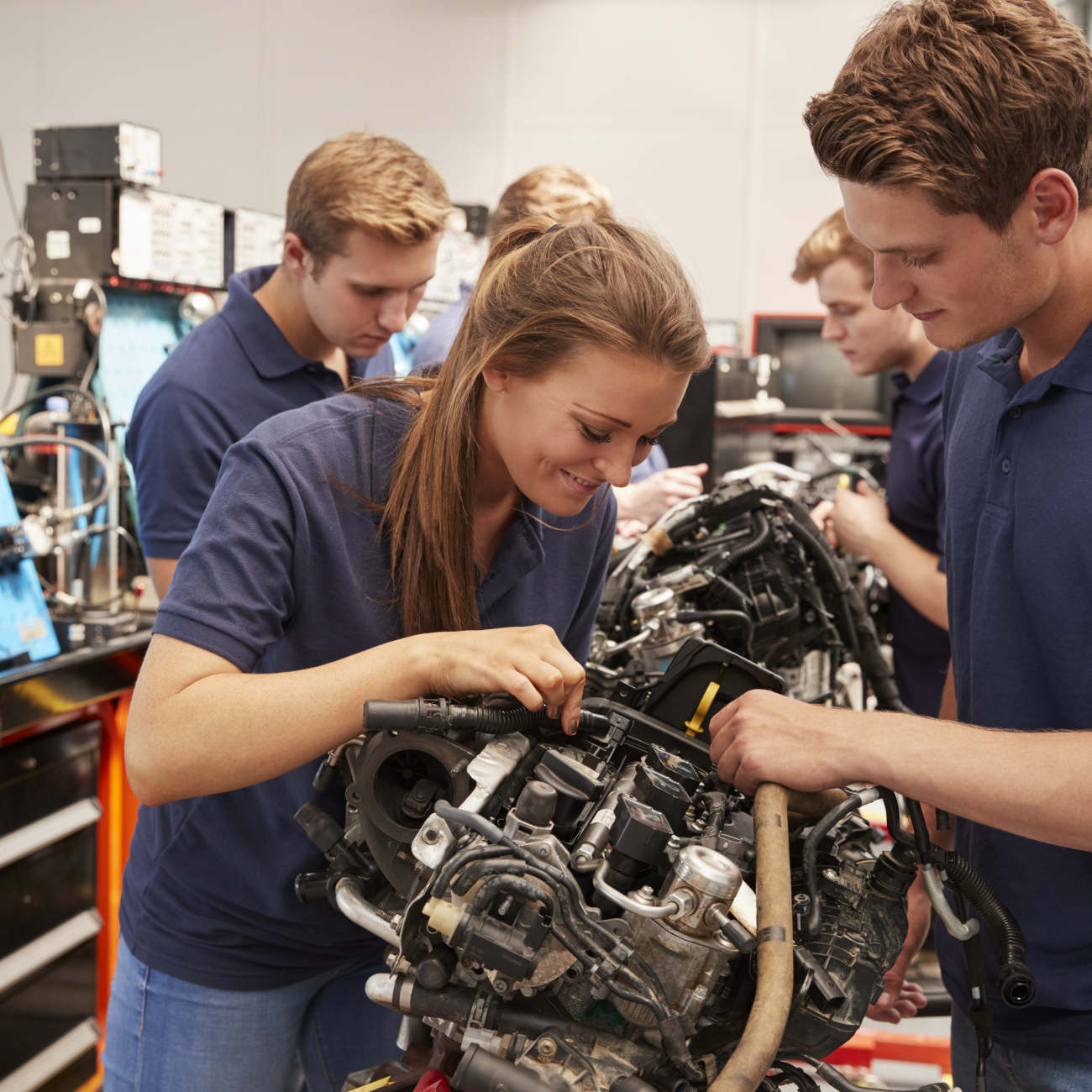 Two students looking at an engine