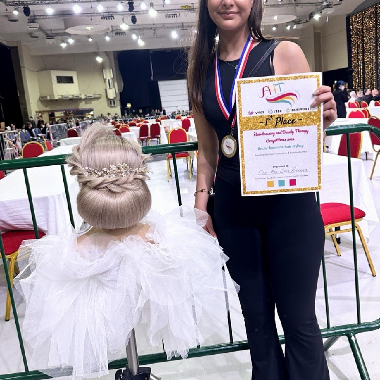 "our hair and beauty apprentice, ellie, styling hair at the competition"