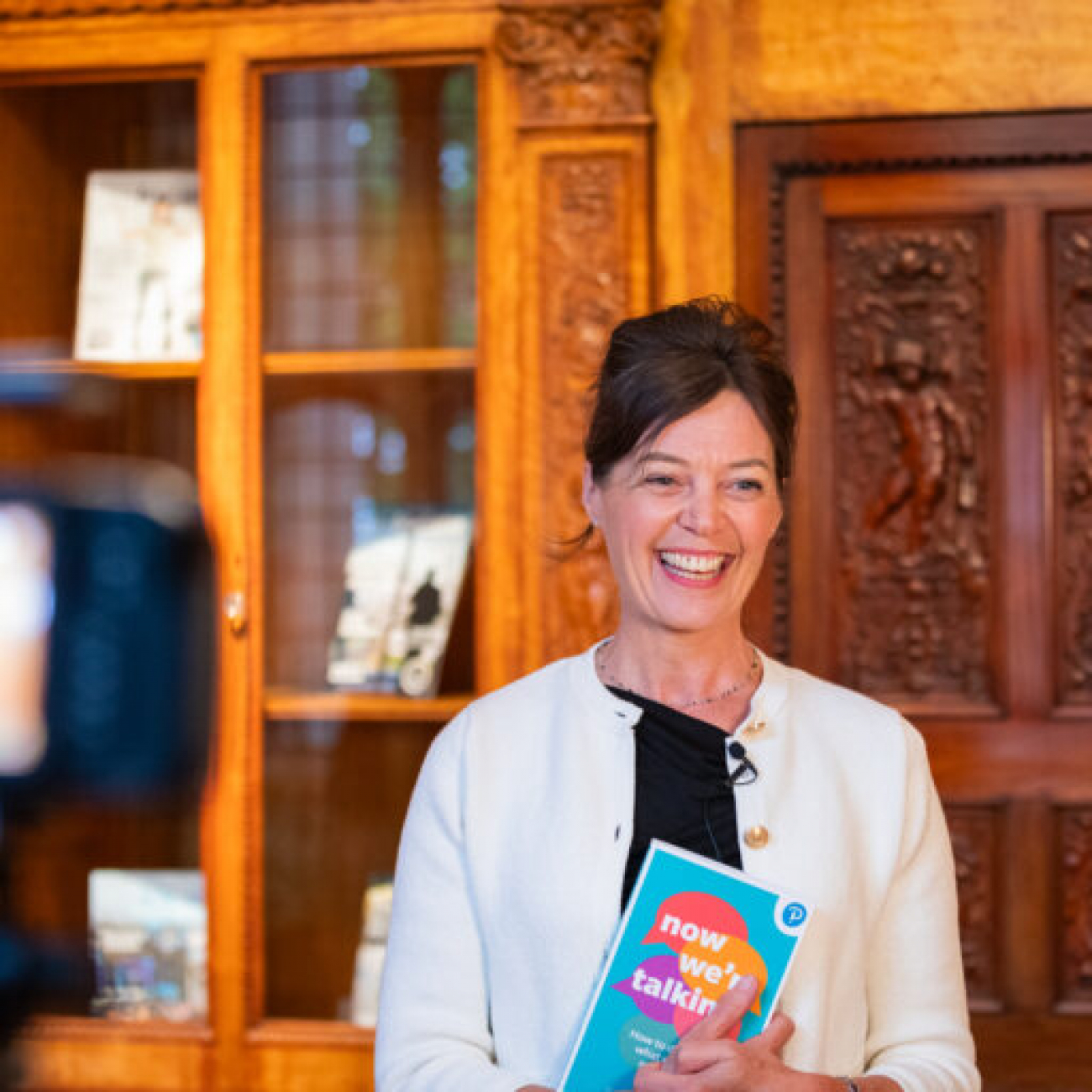 Sarah Rozenthuler holding a book and smiling
