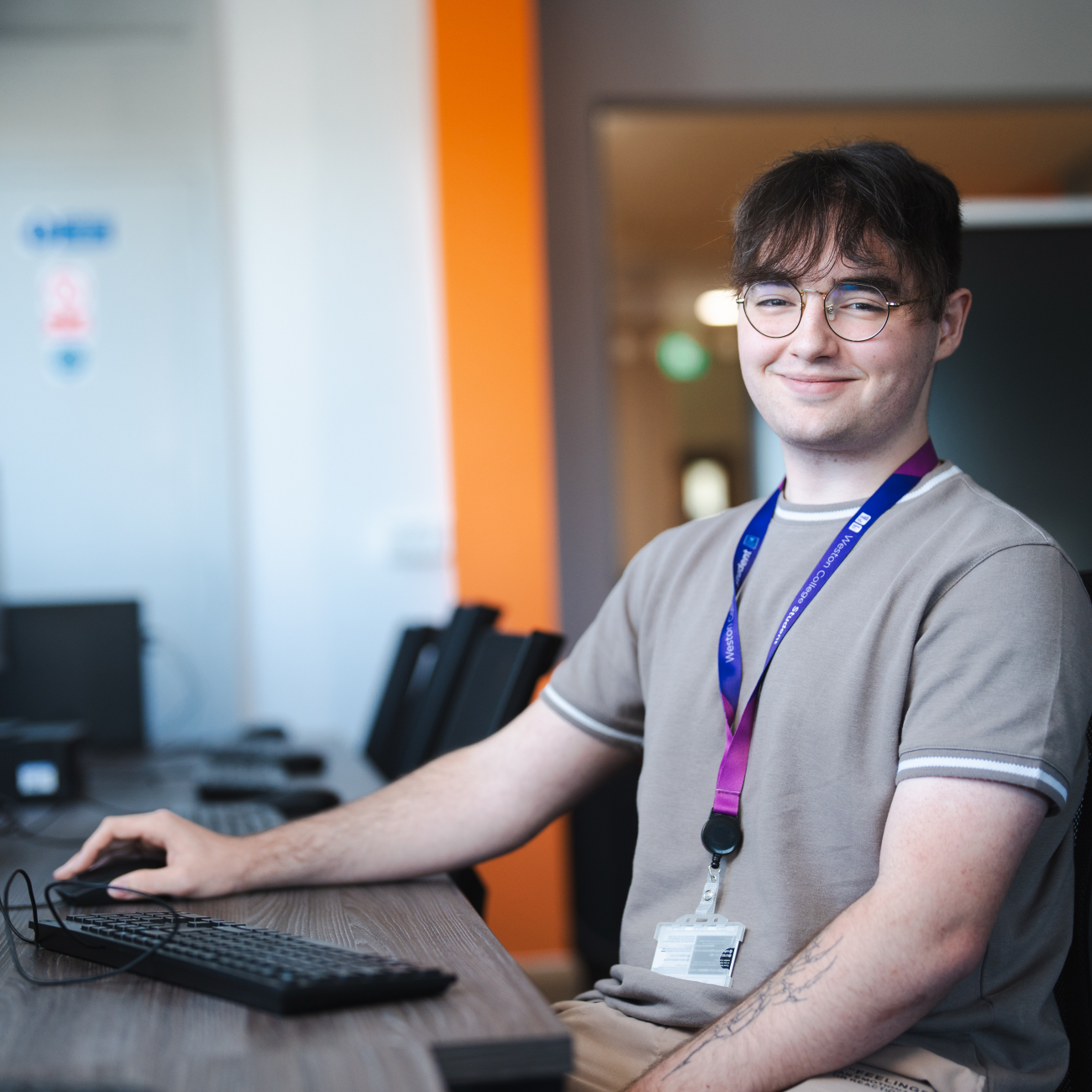 Student sat at a computer smiling