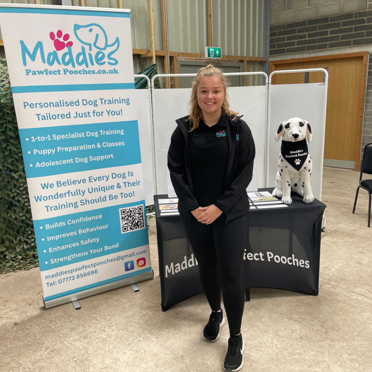 Maddie standing next to her Maddie's Pawfect Pooches banner and stand