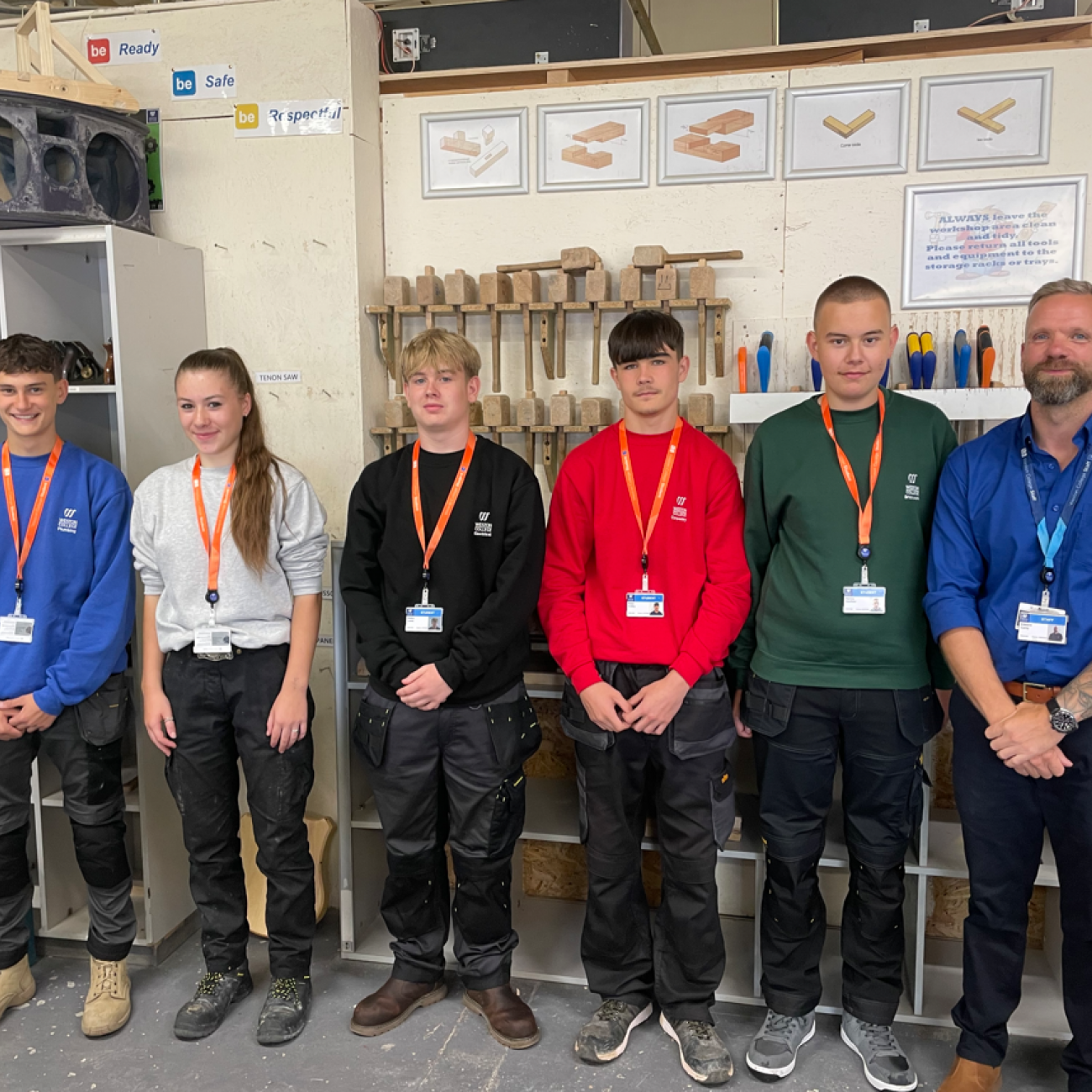 Construction learners from each trade standing smiling in their new uniform