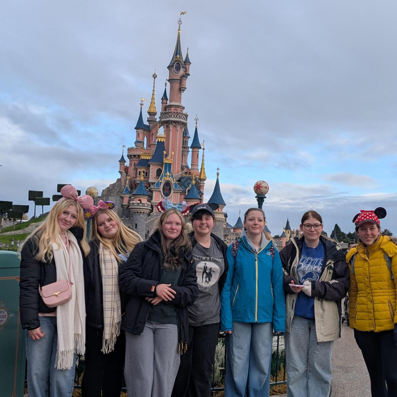 Students smiling by the Disney castle