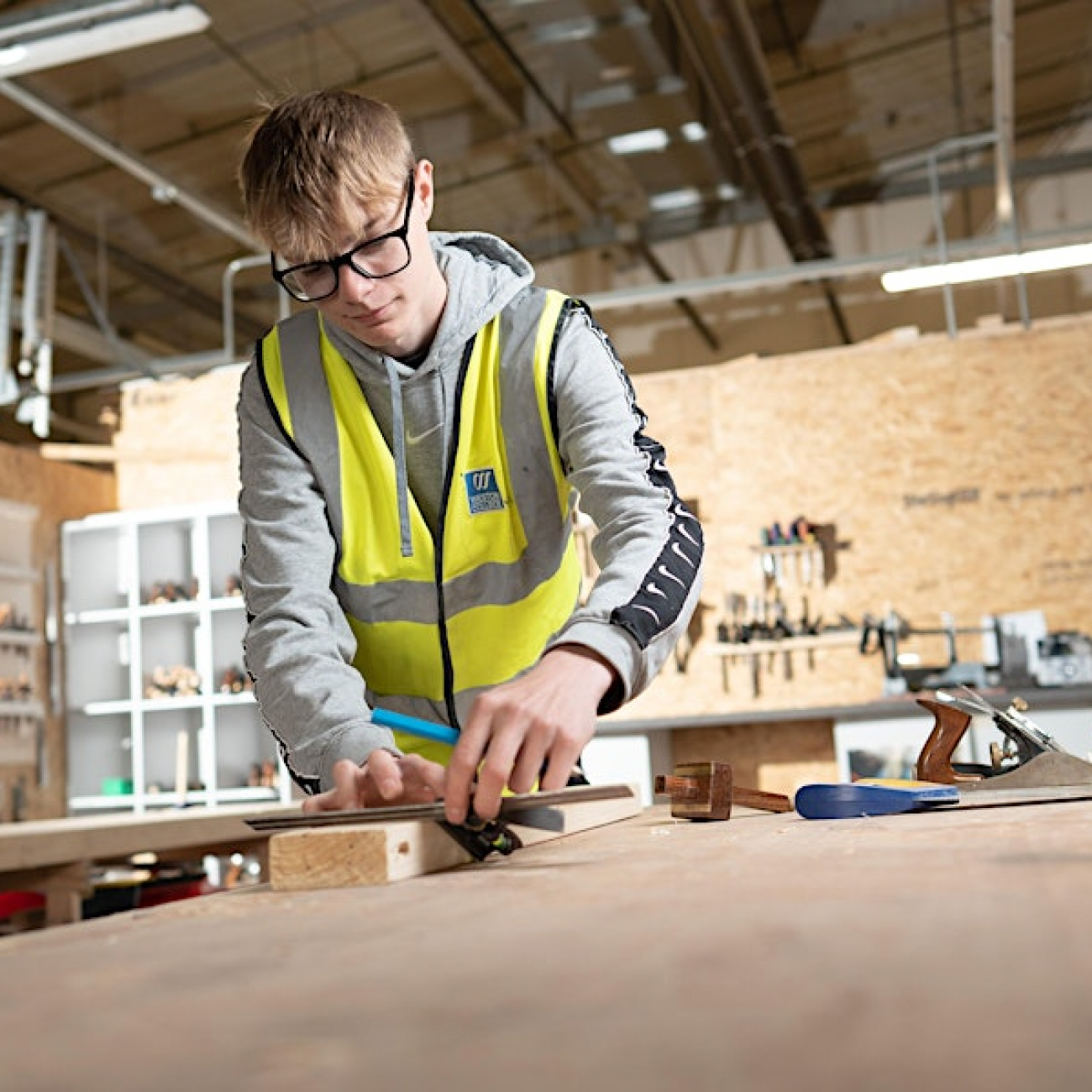 Construction learner measuring wood