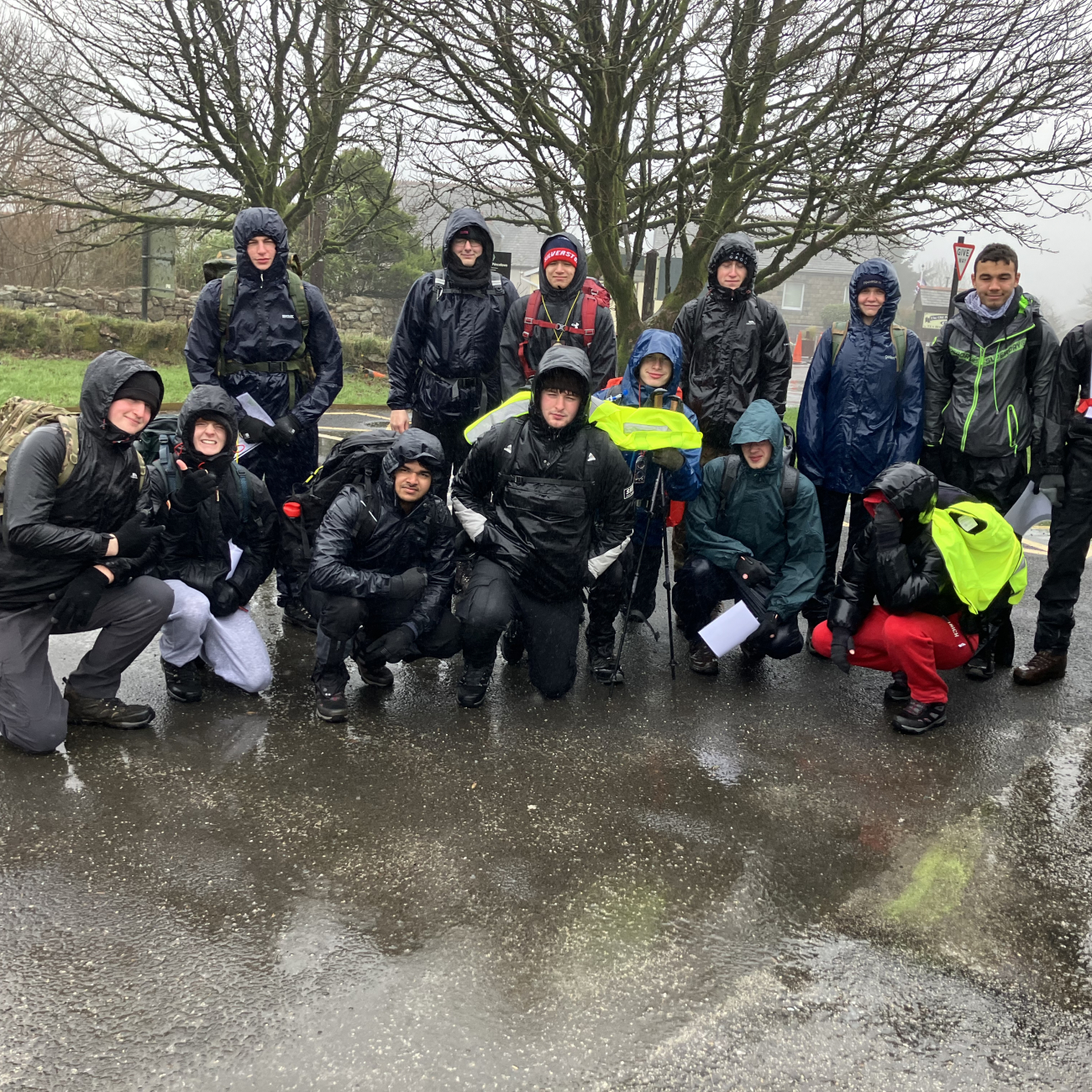 Protective Services students standing smiling soaked in the rain