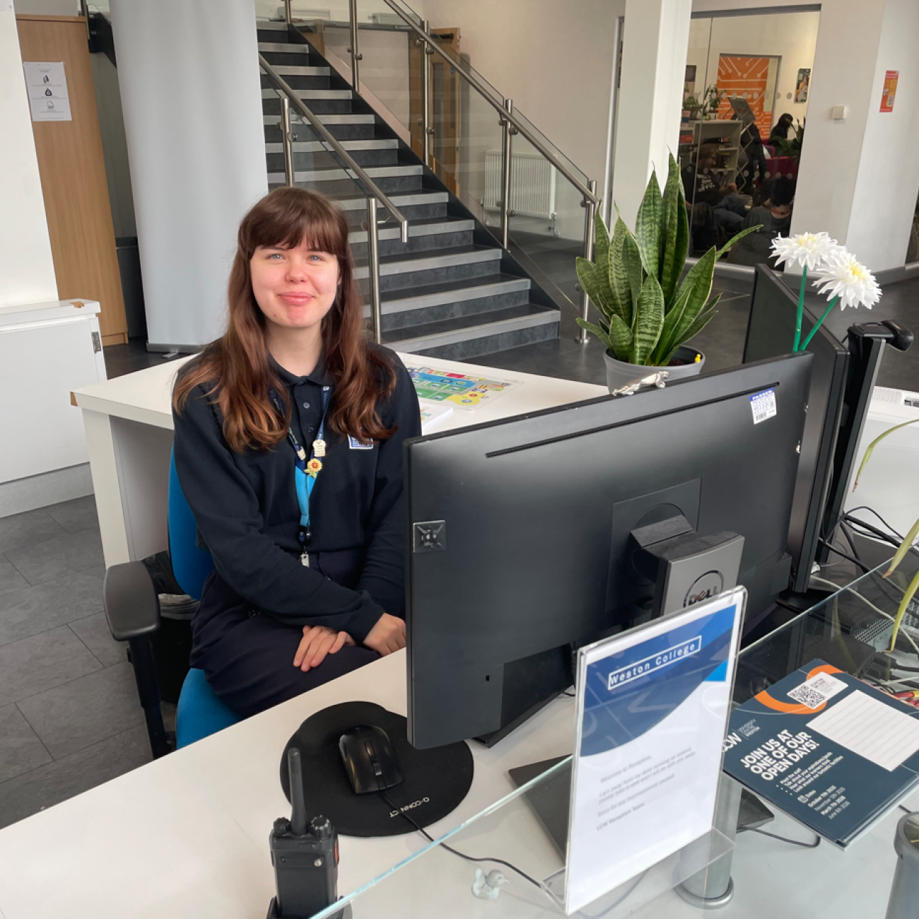 India sat behind the reception desk smiling
