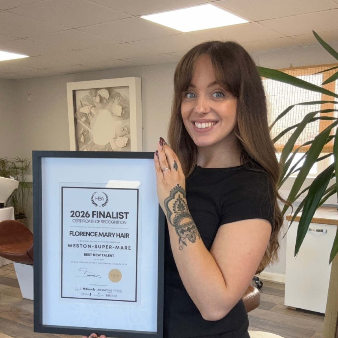 Florence in salon holding up award