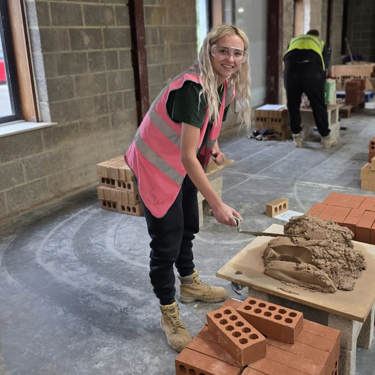 Izzy bricklaying her wall