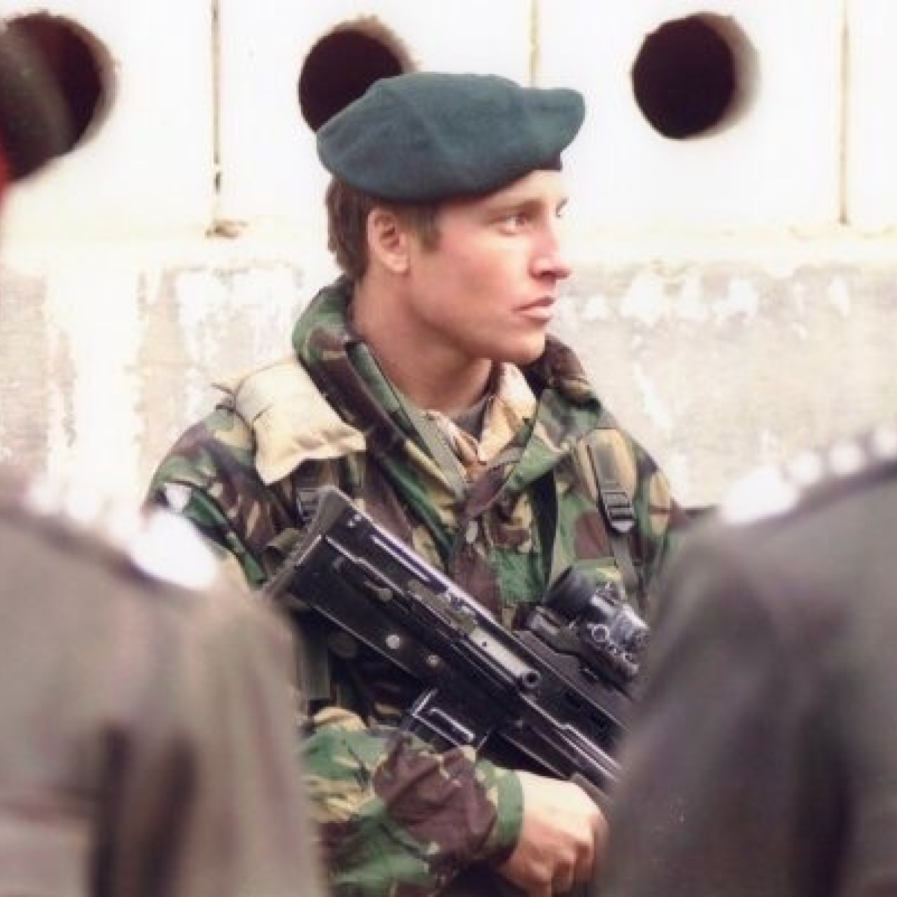 A picture of Darran when he was a Royal Marines Commando. He is dressed in his soldier's uniform and is carrying a gun. 