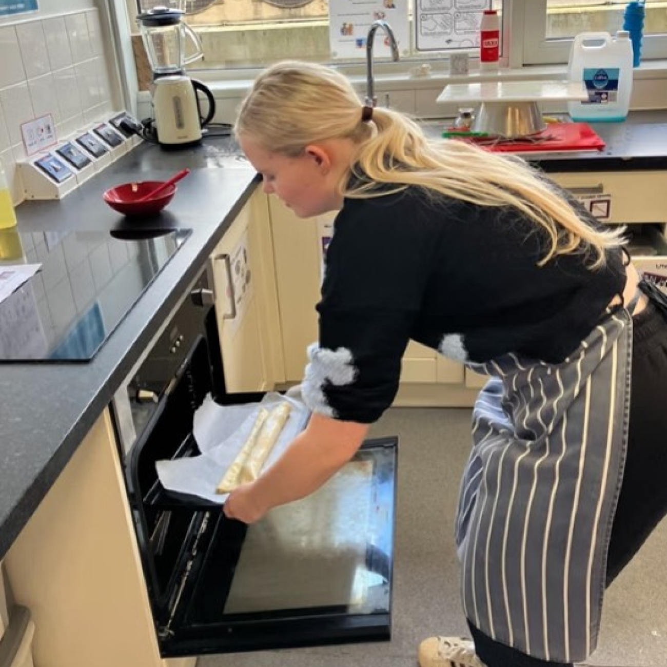 Student putting something in the oven at her work experience placement