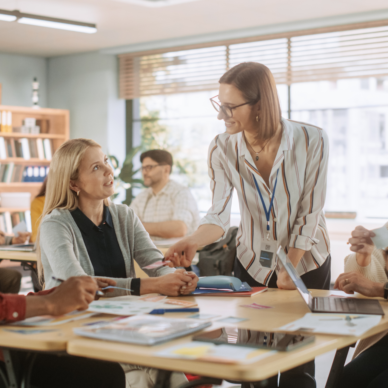 Adult learners sat around classroom table with teacher