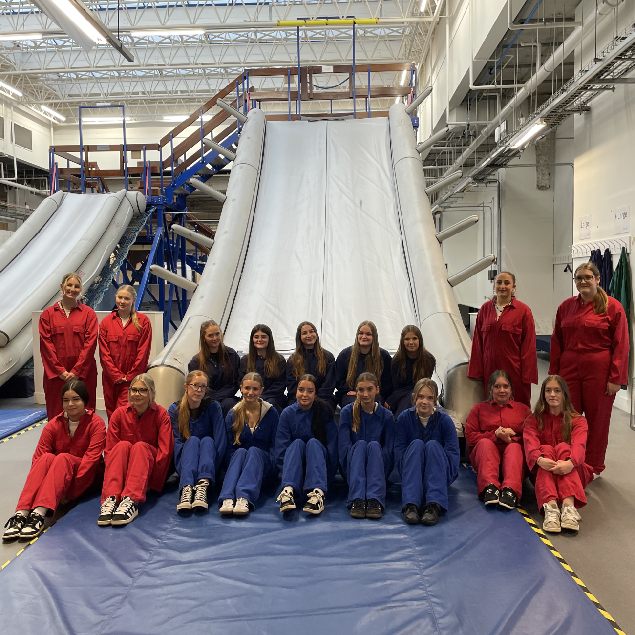 Students sat on the end of an inflatable training slide