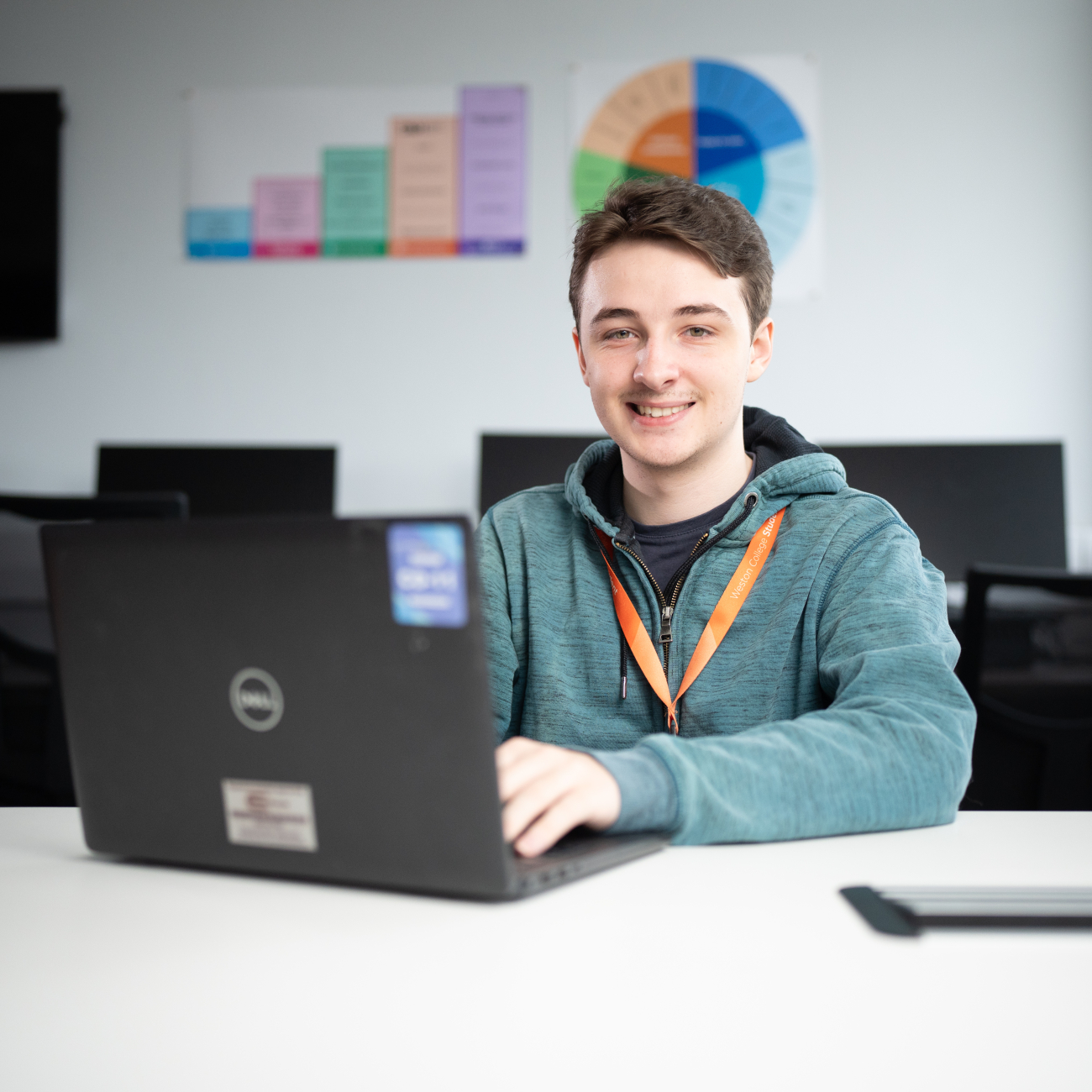 Student sat at desk working on his laptop