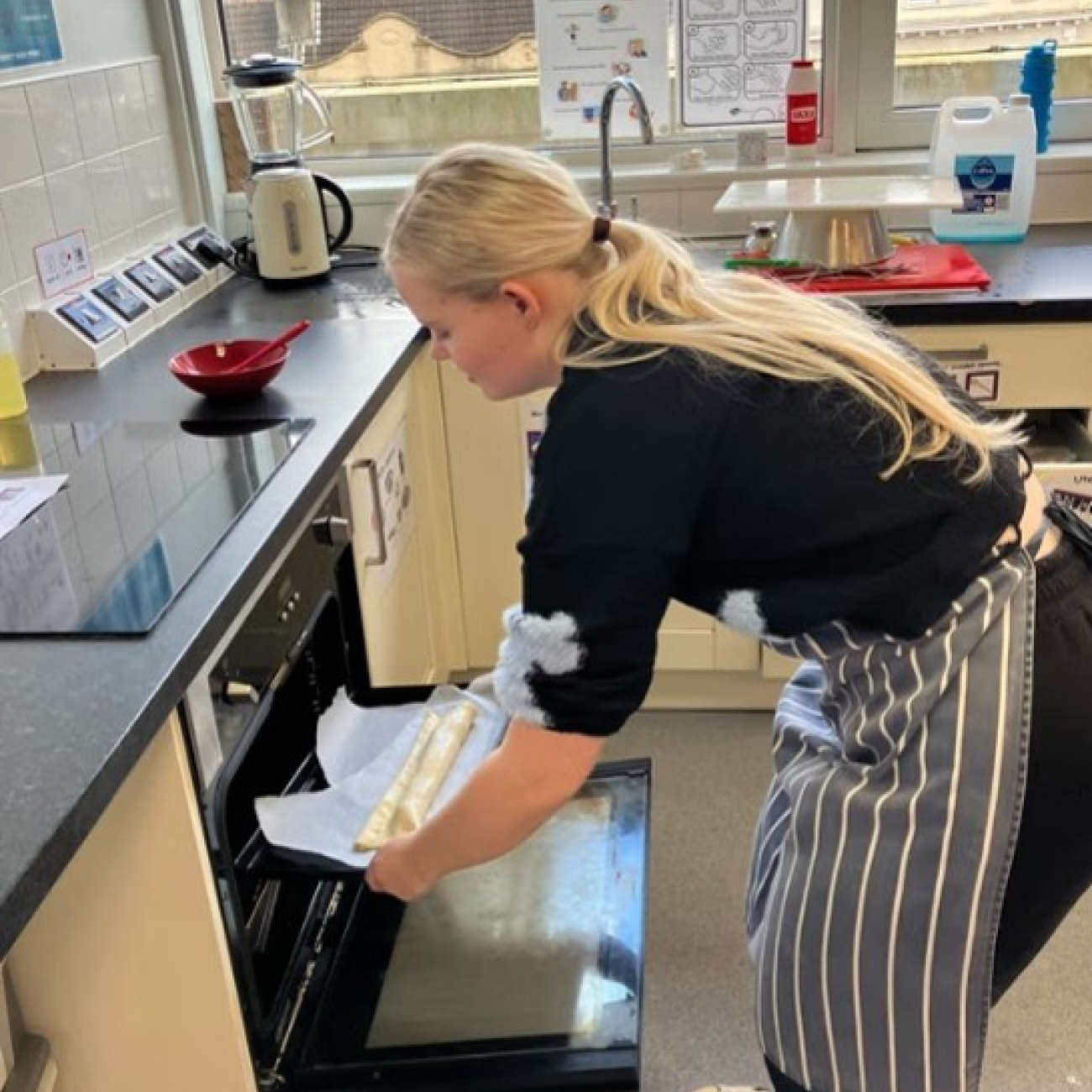 Student putting something in the oven at her work experience placement