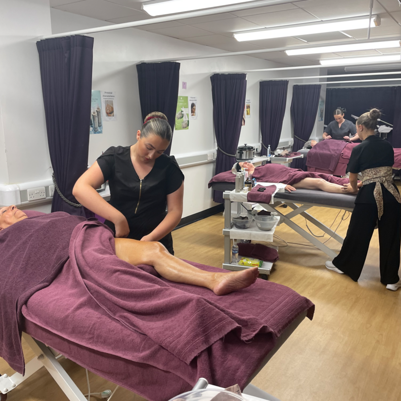 Competitors completing hot stone massages on clients
