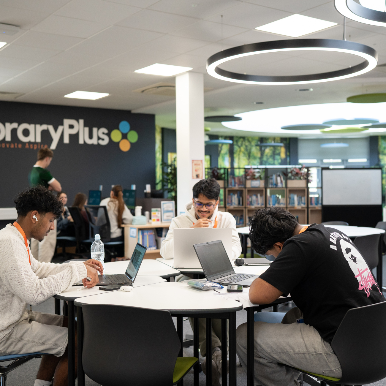 Learners studying in the library on their laptops