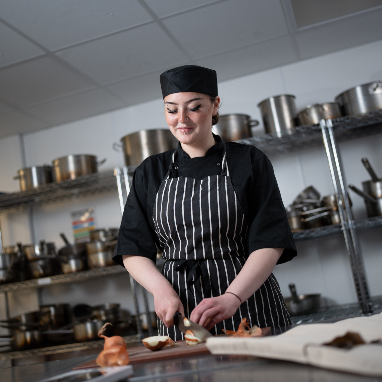 Hospitality student cutting onions in the Weston College kitchen