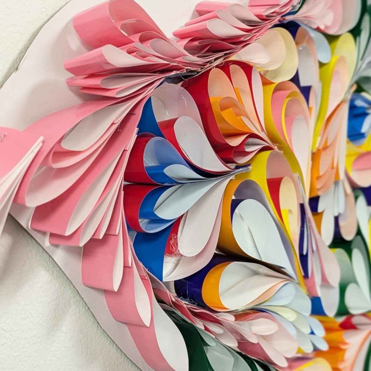Artwork created by students made up of coloured paper swirls