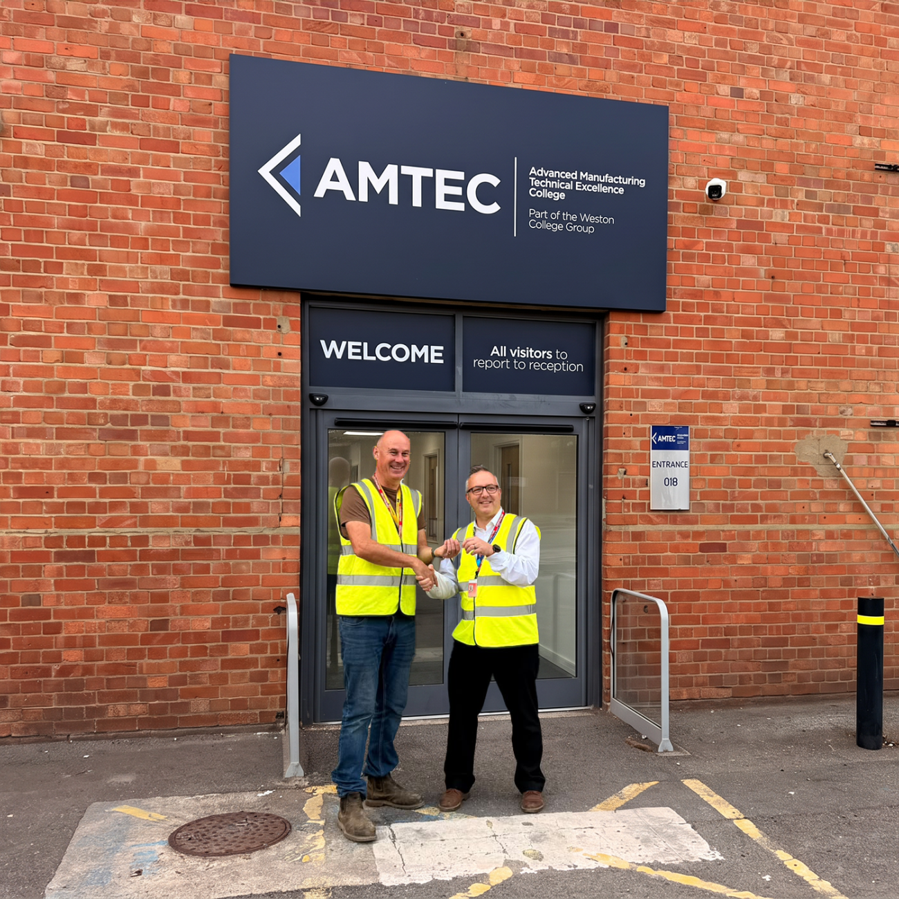 Mark and Andy Shaking Hands in front of AMTEC Building
