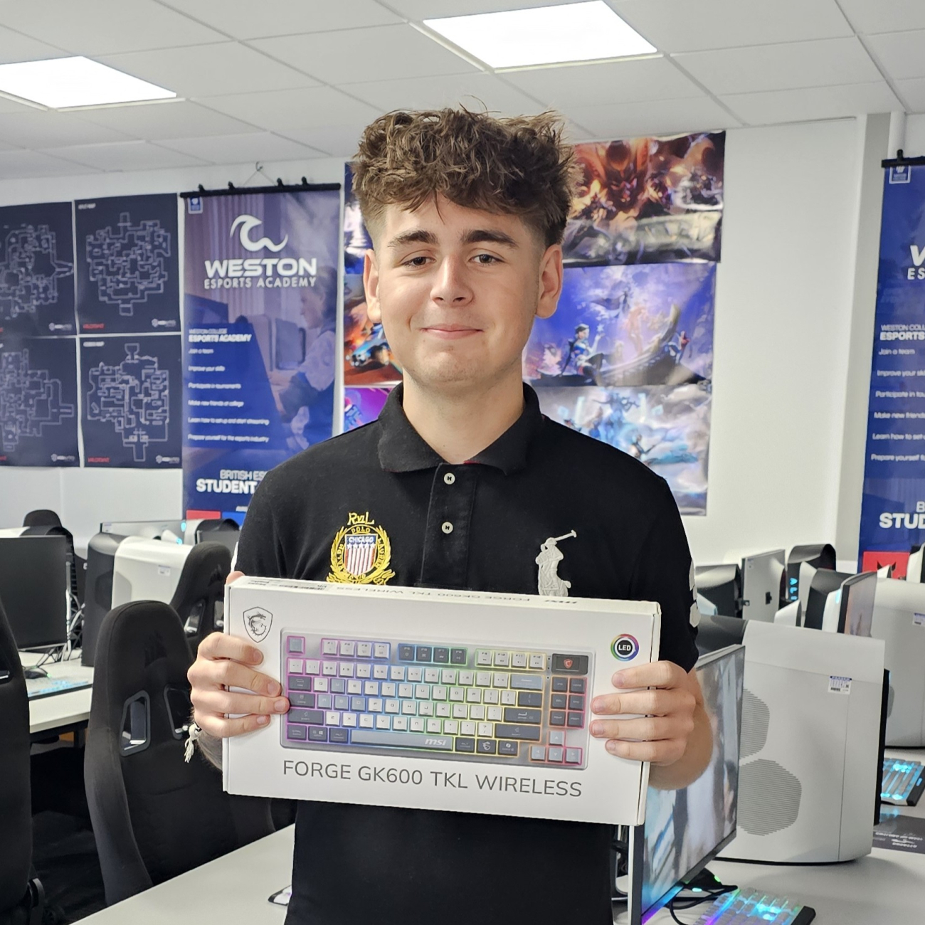 Student smiling and holding the MSI Keyboard he won