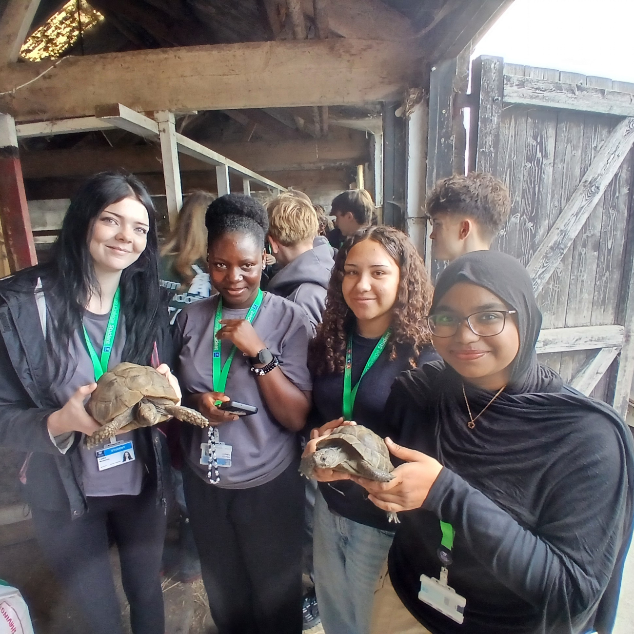 T Level Construction students smiling holding tortoises