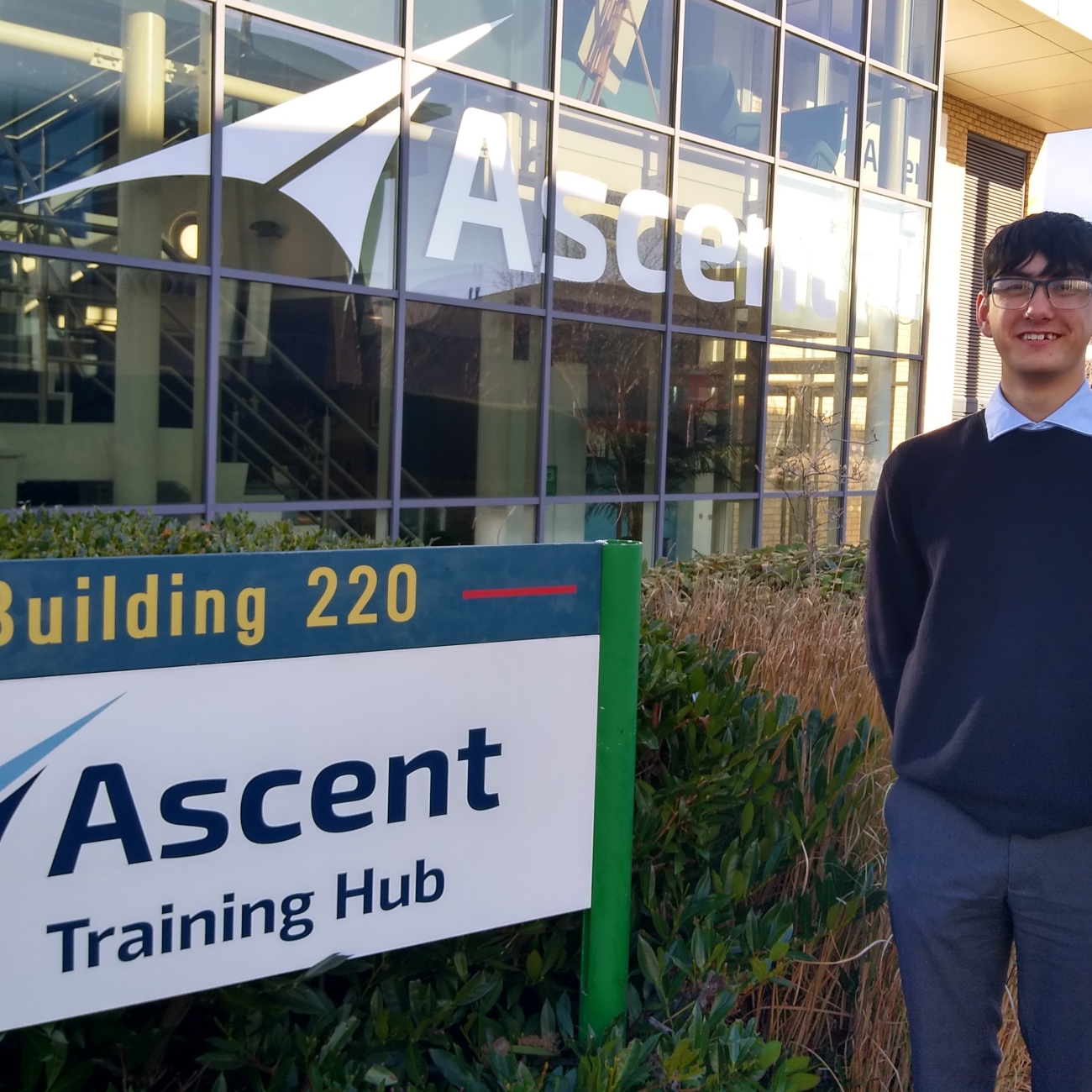 Aidan stood in front of the ascent flight training building and sign