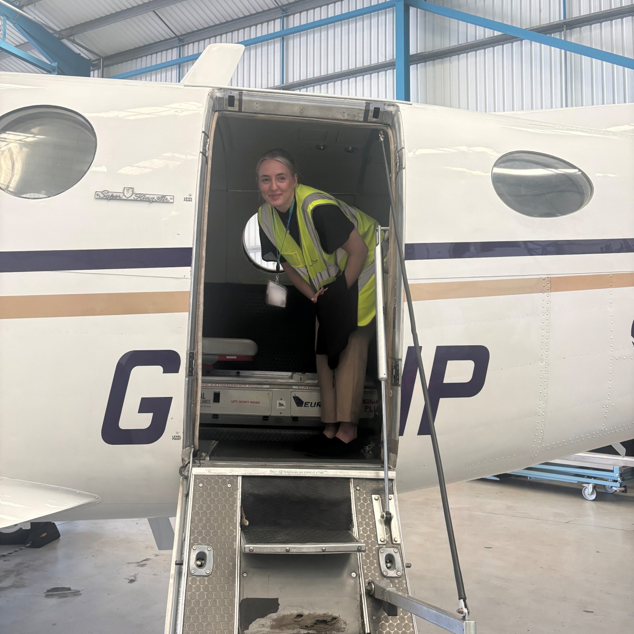 Sophie stood inside a plane smiling