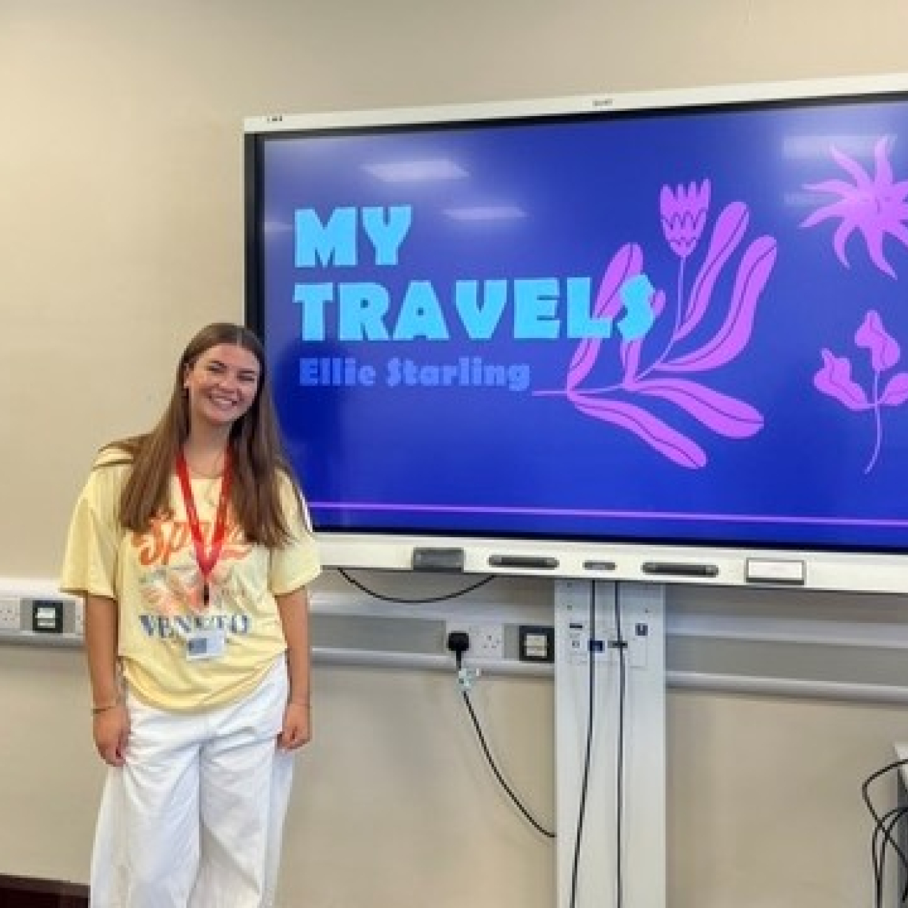Ellie smiling next to the powerpoint presentation she made