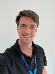 Matt Hillier stood against a white wall smiling at camera