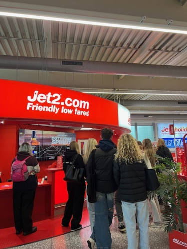 Students exploring the Jet2 information desk at the airport