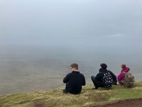 Students sitting in front of a view of South Wales valleys