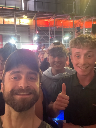 2 students taking a selfie with Daniel Radcliffe