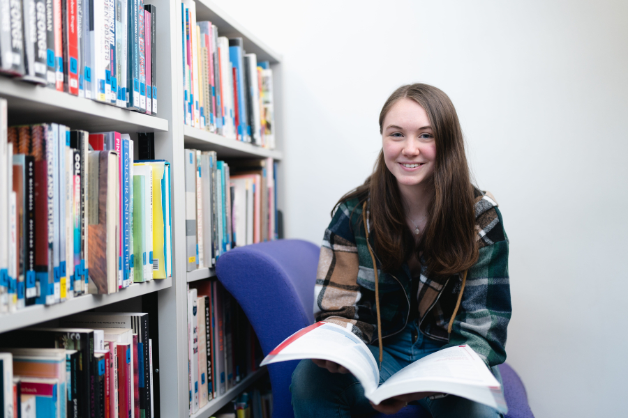 Olivia lee smiling holding a book