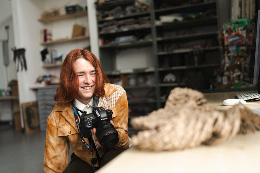 Student studying photography in weston-super-mare holding camera in photography studio
