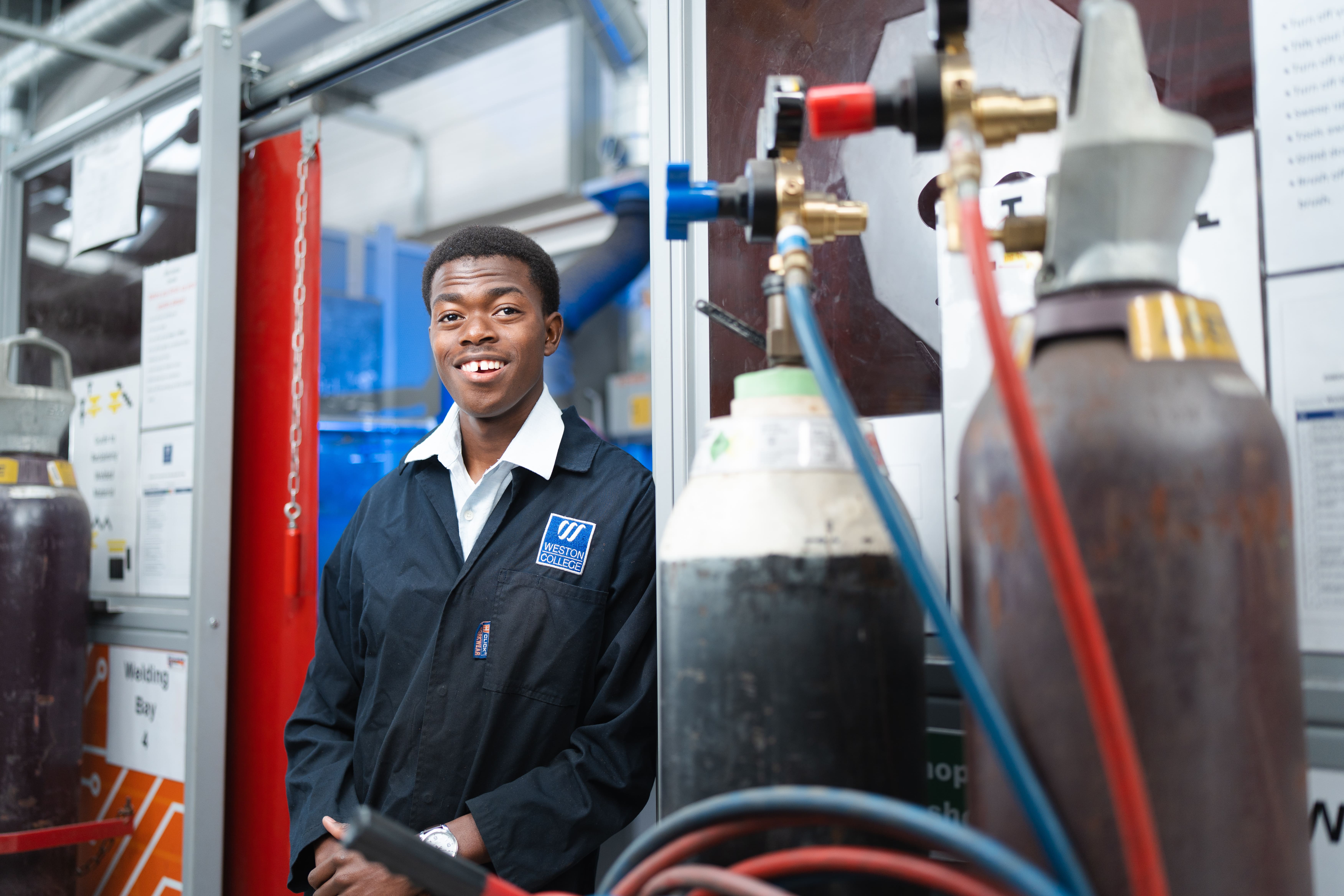 male student standing by a gas cylinder