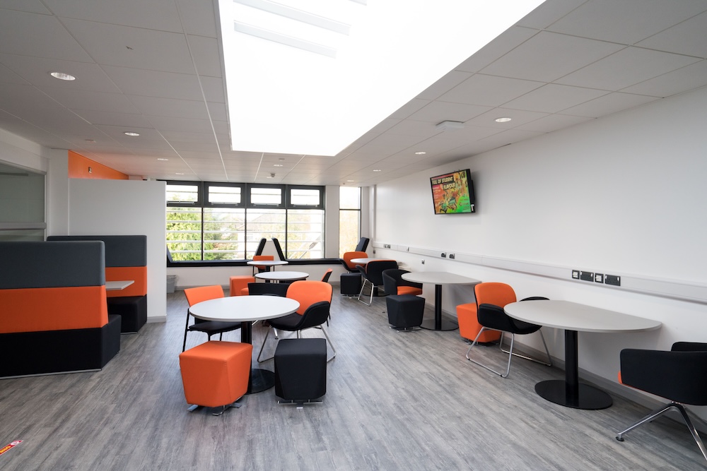 Communal area at WEIOT with table and chairs decked out in WEIOT orange and black